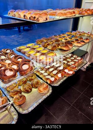 Danish pastry shop with shelves full of freshly cooked pastries in the morning. Stock Photo