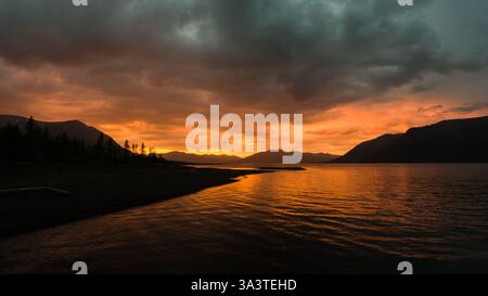Fiery Sunset Over Mountain Lake Stock Photo
