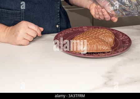 Confectioner removing chocolate Easter egg mold. Stock Photo