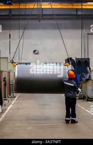 Pipe on overhead crane. Worker with remote control. Stock Photo