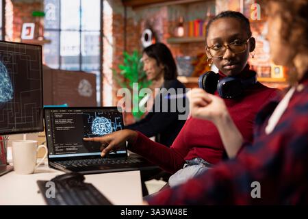 Startup engineers leveraging artificial intelligence tech in workspace to gain competitive edge. Silicon Valley company IT professionals cooperating to do rapid technological advancement Stock Photo