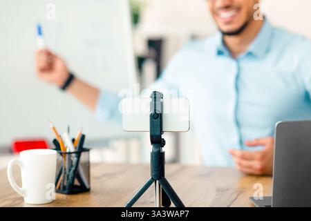 Young Arab businessman engaging in online presentation from office workspace Stock Photo