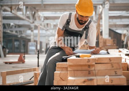 Contractor is busy. Industrial worker in wooden warehouse. Stock Photo