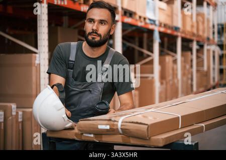 In white hard hat. Foreman is in the storehouse, shipping distribution business. Stock Photo