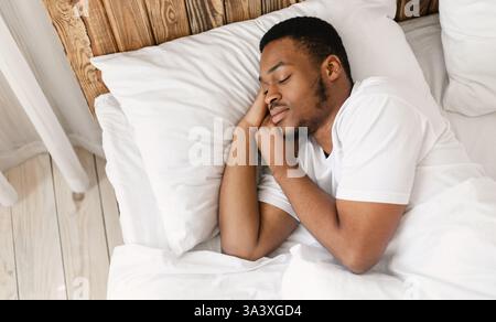 African American Man Sleeping Peacefully In Comfortable Bed At Home Stock Photo