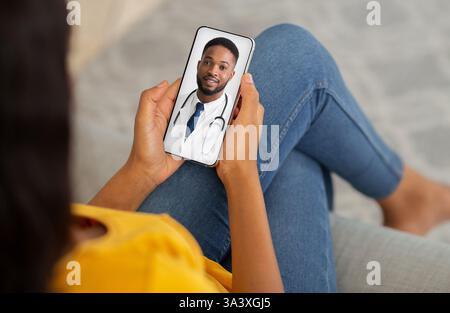 Telemedicine Concept. Unrecognizable Black Lady Using Smartphone, Making Video Conference With Doctor Stock Photo