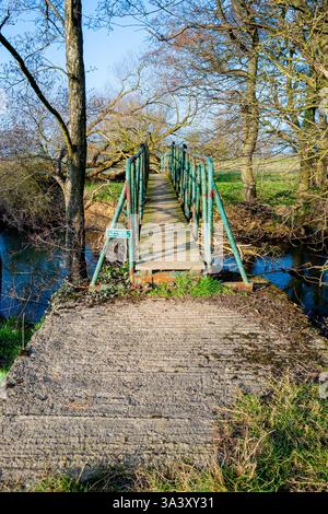 Private steel foot bridge over the River Rye, Nunnington, North Yorkshire. Stock Photo