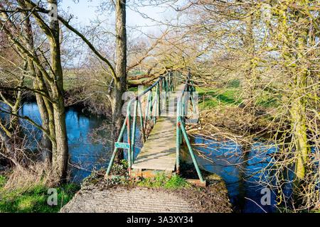Private steel foot bridge over the River Rye, Nunnington, North Yorkshire. Stock Photo