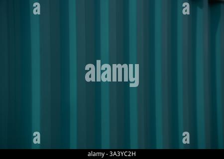 close up of green vertical lines of side of corrugated metal of an industrial container horizontal image for backdrop background shadows and lines Stock Photo