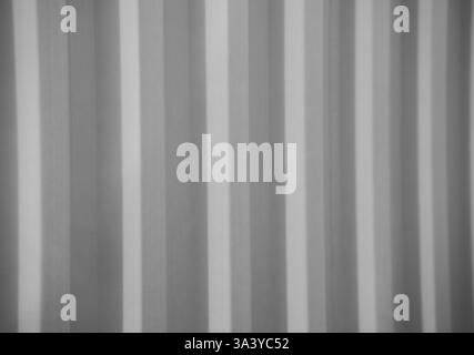 black and white image of vertical lines of side of corrugated metal of an industrial container horizontal image for backdrop background linear concept Stock Photo