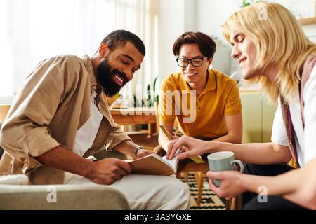 Three diverse young men bond over books and ideas during a casual home book club. Stock Photo