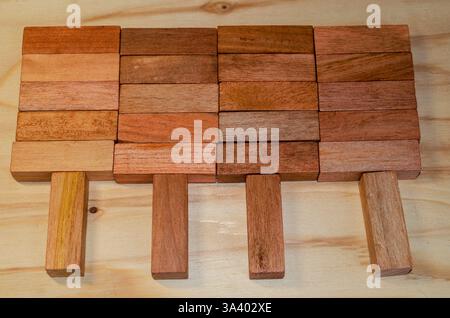 Wooden blocks arranged to show the concept of people working as a team cooperating to lift a heavy load Stock Photo