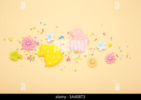 Tasty Easter cookies in shape on bunny and candies on beige background. Top view Stock Photo