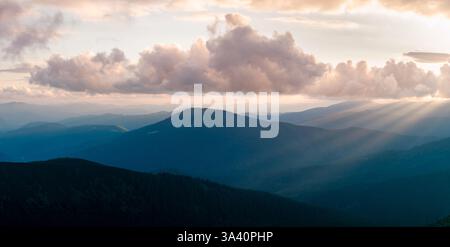 Stunning spring mountain scenery with rolling blue ridges glowing in the warmth of the rising sun. Carpathian mountains. Landscape photography Stock Photo