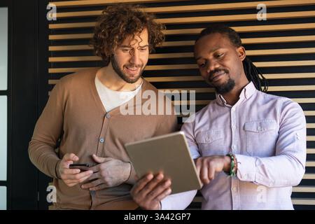 Two business people working together using digital tablet pc and talking about a business project. Stock Photo