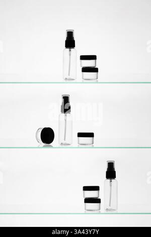 Empty cosmetic products on a glass shelves. Mockup transparent bottles of different sizes for advertising on white background Stock Photo