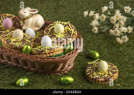 Easter biscuits in the shape of a nest with eggs in a basket in a meadow Stock Photo