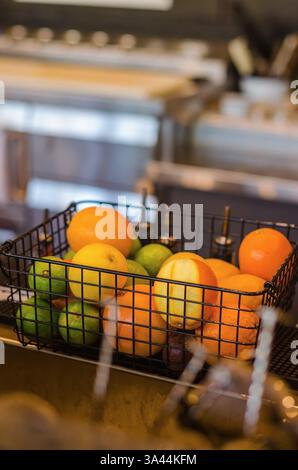 Wire Basket with Oranges and Limes on Counter for preparing cocktails in bar . High quality photo Stock Photo