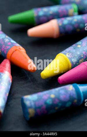 Macro of Small Coloring Crayons on Black Background Vertical Stock Photo
