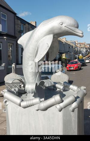 A waste bin featuring a dolphin surrounded by plastic bottles, reducing marine plastic pollution concept, England, UK Stock Photo