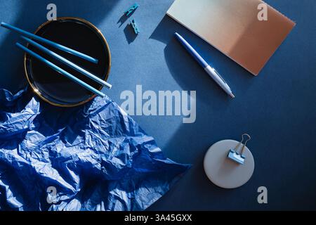 Overhead view of assorted stationery on a blue background Stock Photo