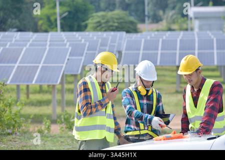 Three engineers having a meeting at a solar powered station, Thailand Stock Photo
