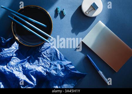 Overhead view of assorted stationery on a blue background Stock Photo