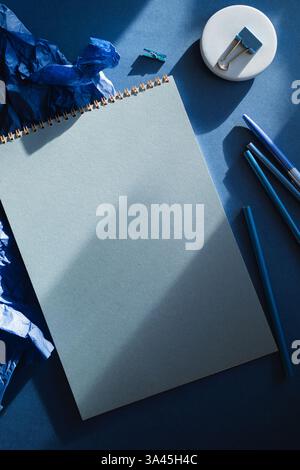 Office desk with stationery on blue background in contrast light Stock Photo