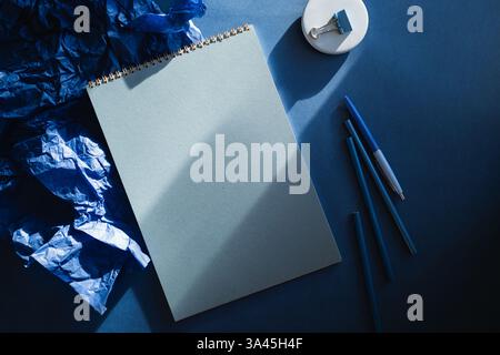 Overhead view of assorted stationery on a blue background Stock Photo