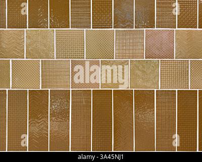 Close up of random textured porcelain tiles in brown and beige color. 3D textured subway tiles in various geometrical pattern and white grouts. Retro Stock Photo