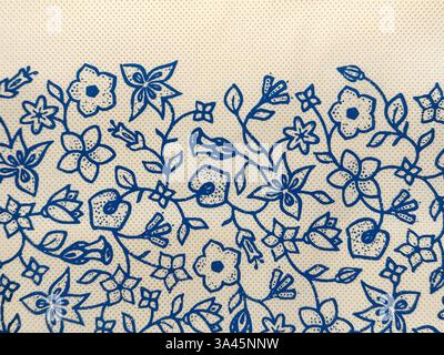Close up of random blue flower engraving sewn on a beige cotton bag. Random leaves and floral swirls pattern drawn and sewn on a beige fabric. Seamles Stock Photo