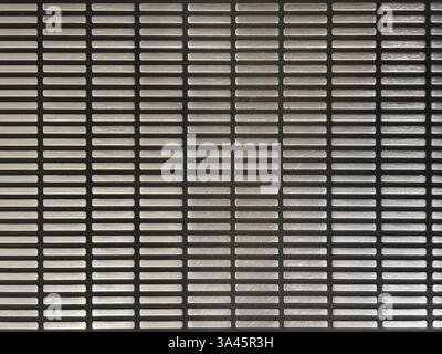 Close up of escalator landing metal plate with stripes and silver metallic subway tiles. Seamless background texture. Stock Photo