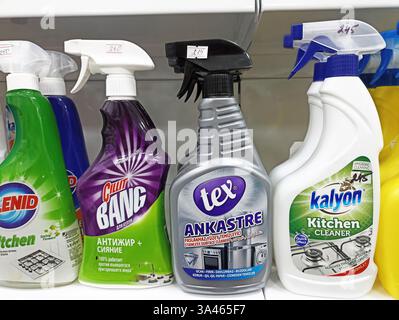 Assorted household cleaning products on store shelf with spray bottles. Stock Photo