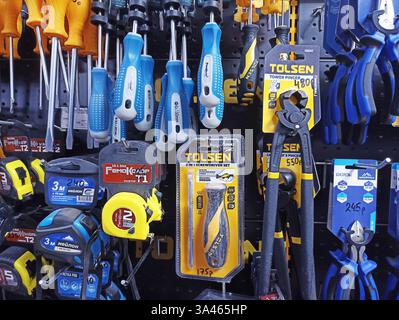 Assorted hand tools displayed on wall in hardware store. Stock Photo