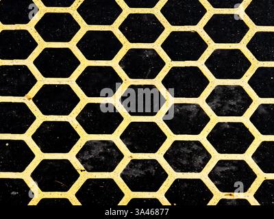 A bold black and yellow hexagonal pattern with an industrial texture, perfect for abstract backgrounds, graphic design, and modern geometric concepts. Stock Photo