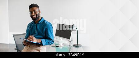 Successful young African American businessman working in modern office Stock Photo