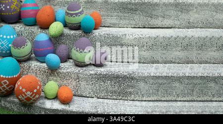Vibrant assortment of decorative Easter eggs nestled on weathered stone steps, selective focus. The colorful arrangement symbolizes festive spirit of Stock Photo