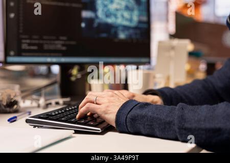 Startup programmer leveraging artificial intelligence tech in office to gain competitive edge. Close up of AI specialist typing on PC keyboard, working on rapid technological advancement Stock Photo