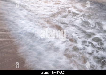 Long exposure abstract waves breaking on a beach Stock Photo