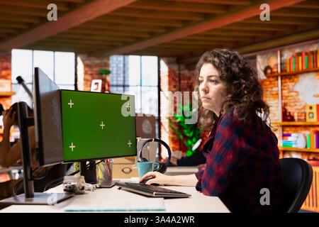 Technician using isolated screen computer to do maintenance on artificial intelligence neural networks. Woman in tech startup office using AI systems on chroma key PC display Stock Photo