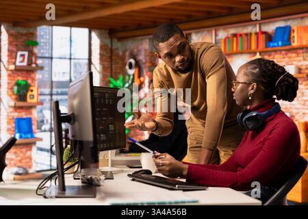 Team of admins collaborating in innovative startup office using programming languages to build application. Software development agency IT coworkers doing brainstorming, optimizing code on computer Stock Photo