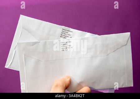 Paris, France - Mar 10, 2025: A hand holds two white envelopes with printed return address from Payoneer PO Box 17557 Birmingham UK B33 3EX, clearly v Stock Photo
