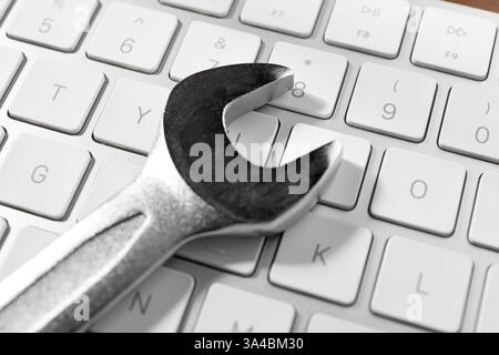 Technical support concept. Wrench on keyboard, closeup Stock Photo