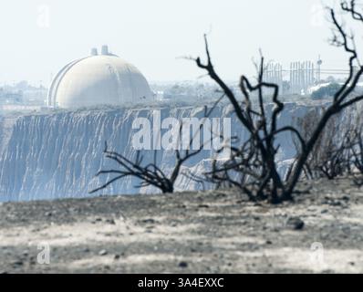May 14, 2014 - San Onofre, California, U.S - The view looking north from the San Onofre State Park of SONGS Containment Dome 3 at the forefront of the photo with Containment Dome 2 behind it.  The charred remains of shrubs and bushes, along with ash and debris from the Pendleton West Freeway Fire were still hot to the touch after the wildfire blew through the area coming as close as a quarter of a mile to SONGS.  The shuttered San Onofre Nuclear Generating Station has begun the process of decommissioning with a Community Engagement Panel made up of local residents as well as mayors, city counc Stock Photo