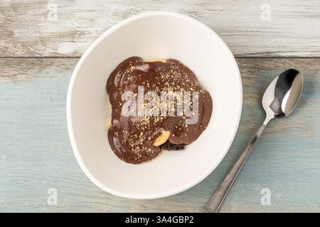 Delicious profiteroles with chocolate sauce on a white porcelain plate Stock Photo