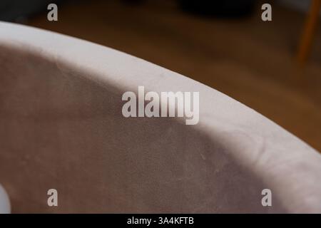Close-Up Detail View of Smooth Beige Upholstered Furniture Edge with Blurred Background. Stock Photo
