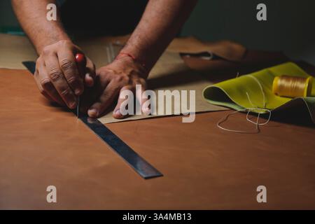Shoemaker working leather using tools and ruler Stock Photo
