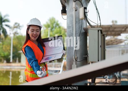 Female engineer managing solar project documentation at a construction site. Stock Photo