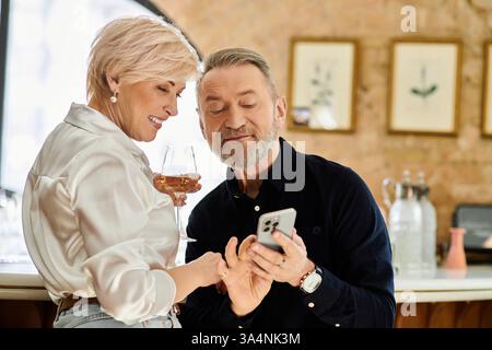 A mature couple enjoys their time together, sharing smile and conversation over drinks. Stock Photo