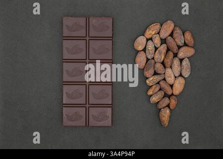 Chocolate bar. Location bubble or pin icon is made from cocoa beans. Black background. Premium chocolate origins. From Bean to Bar. Stock Photo